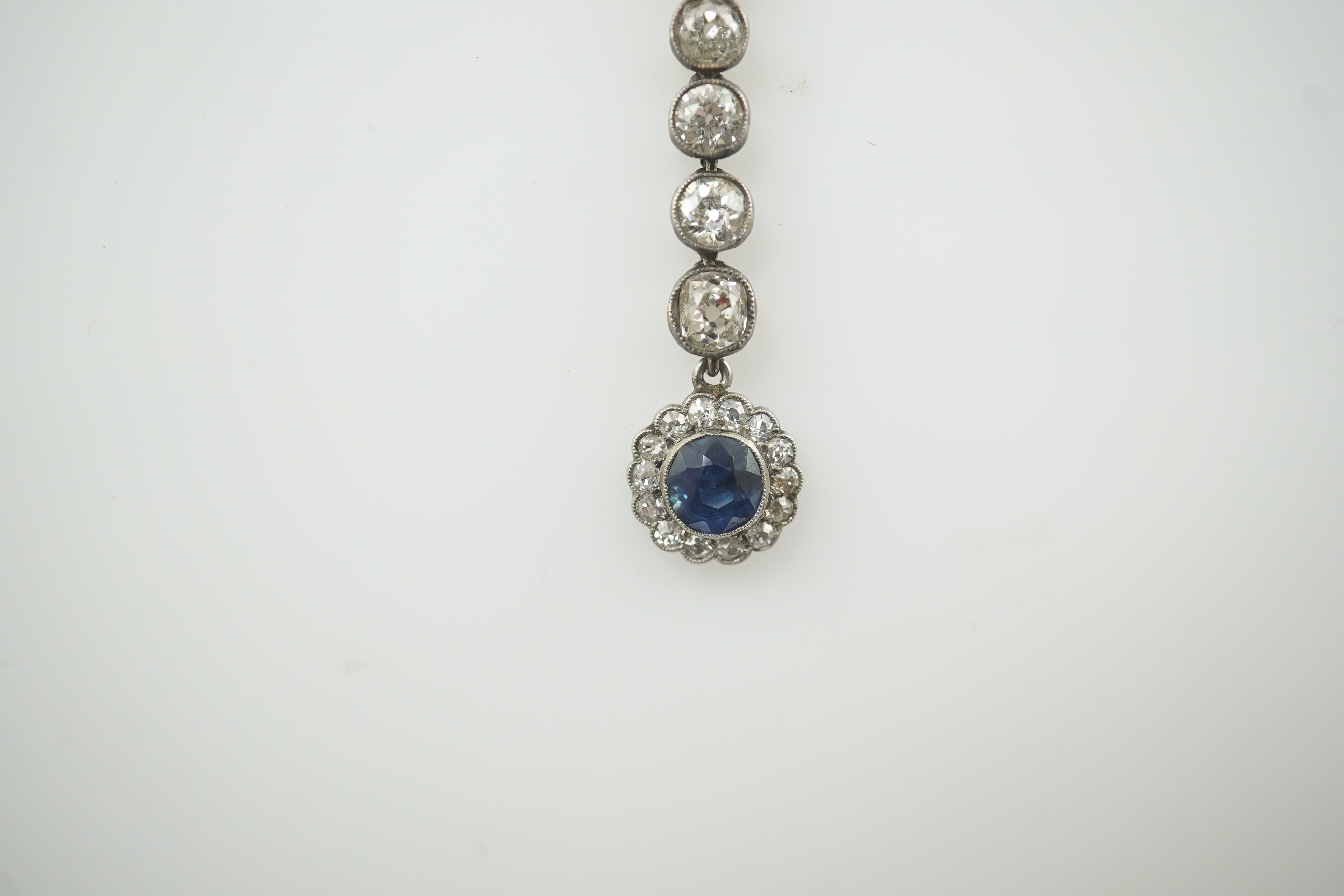 A Belle Epoque gold and silver, millegrain set sapphire and diamond cluster set drop pendant necklace